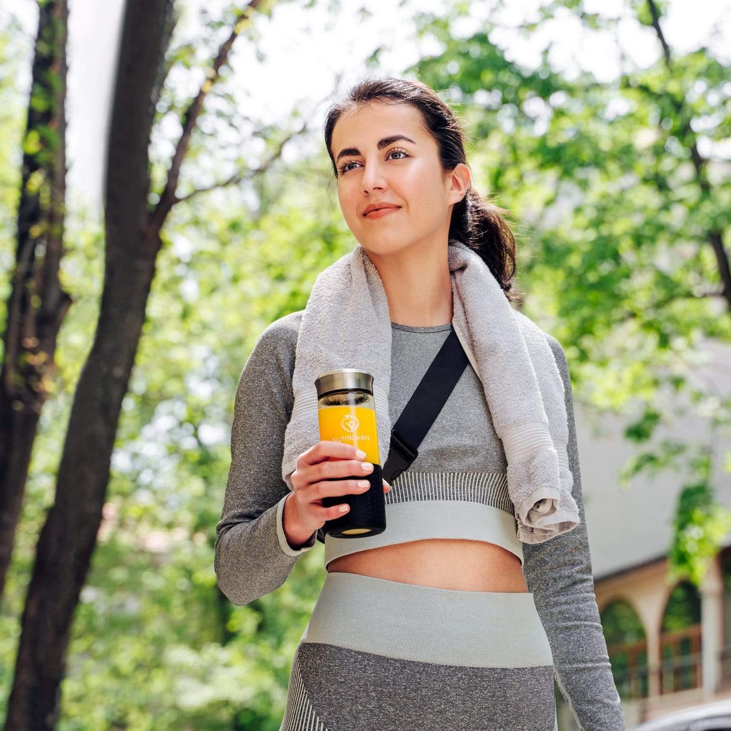 Damen Sportkleidung in Grau, mit gelbem Thermobecher und Handtuch, ideal für aktive Lebensstile.